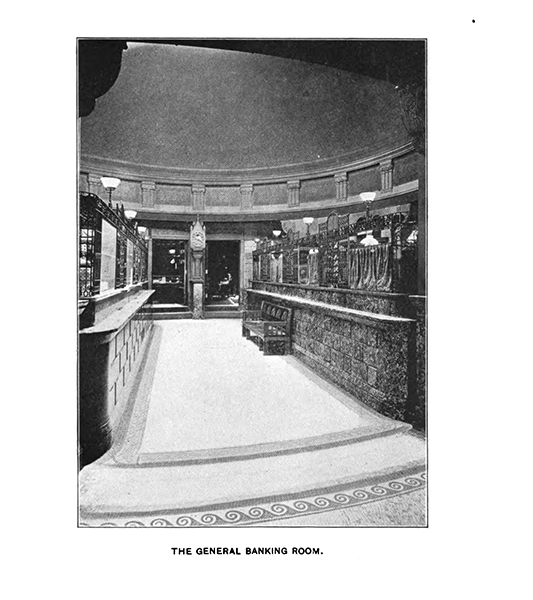 A black-and-white photograph depicting a bank lobby, teller stalls on the left and right. Captioned below as the general banking room.