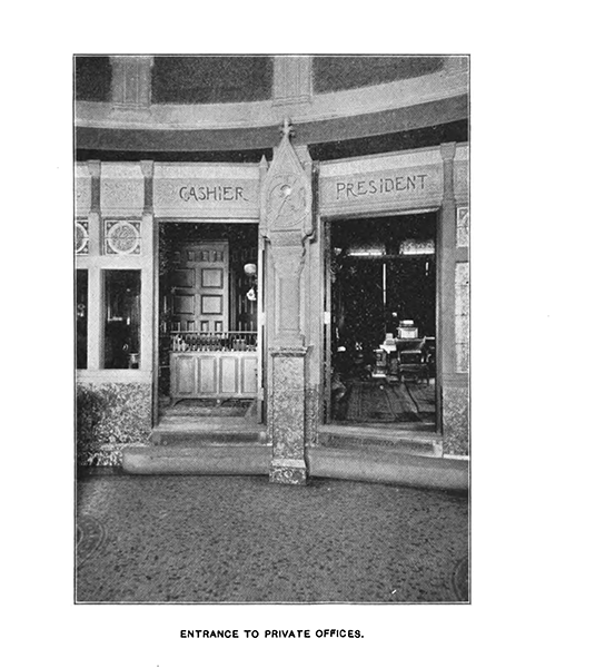 A black-and-white photograph depicting an interior section of the bank with two doorways, with 'cashier' on the left and 'president' on the right.