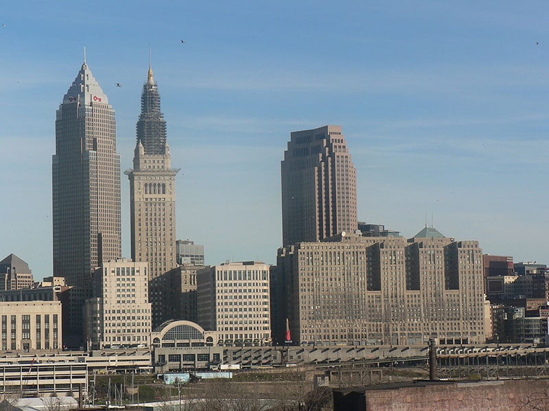 A colored image of the Cleveland skyline with three large skyscrapers much larger than the rest of the skyline.