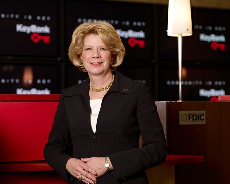 A colored photograph of Beth E. Mooney with KeyBank teller booths in the background.