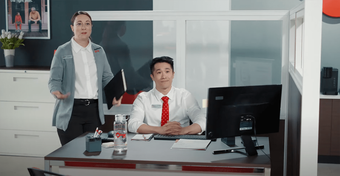 An image of KeyBank employees, one sitting behind a desk and another standing next to him.