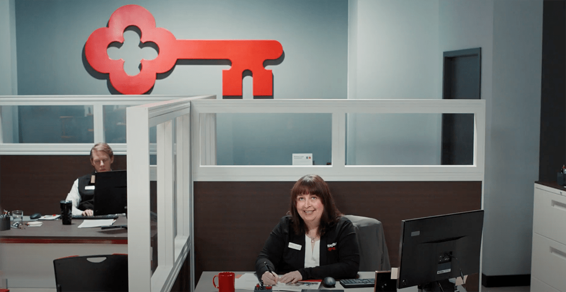 An image of the KeyBank office with two cubicles with employees at their desks.